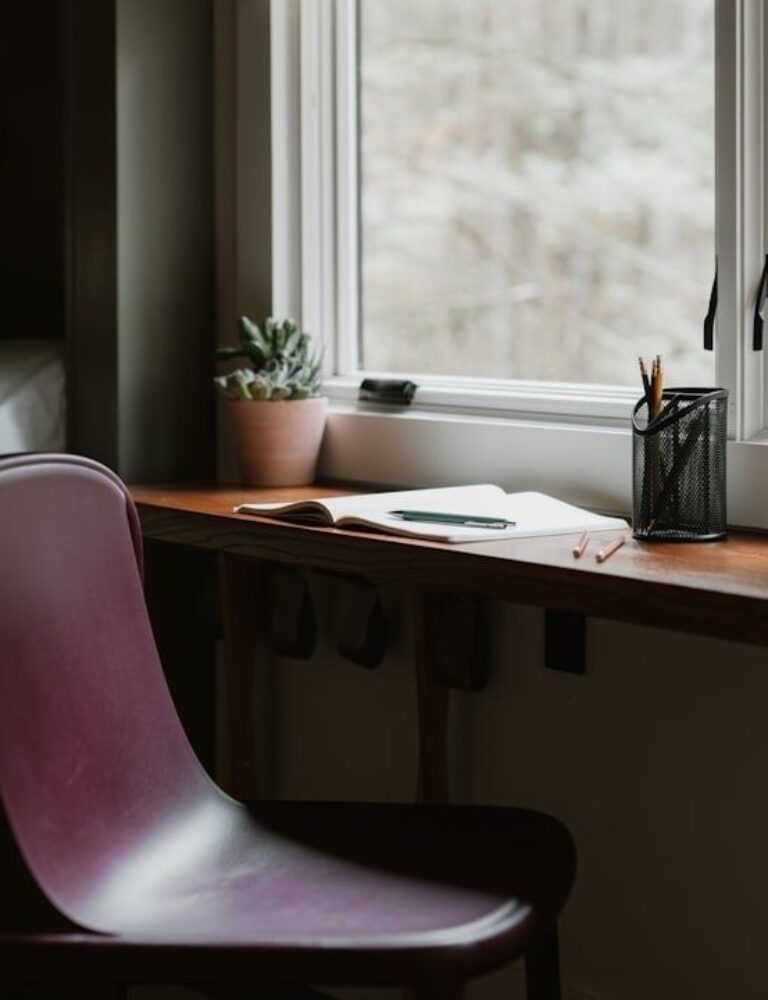 Rustige schrijfhoek met houten bureau, stoel en planten bij het raam