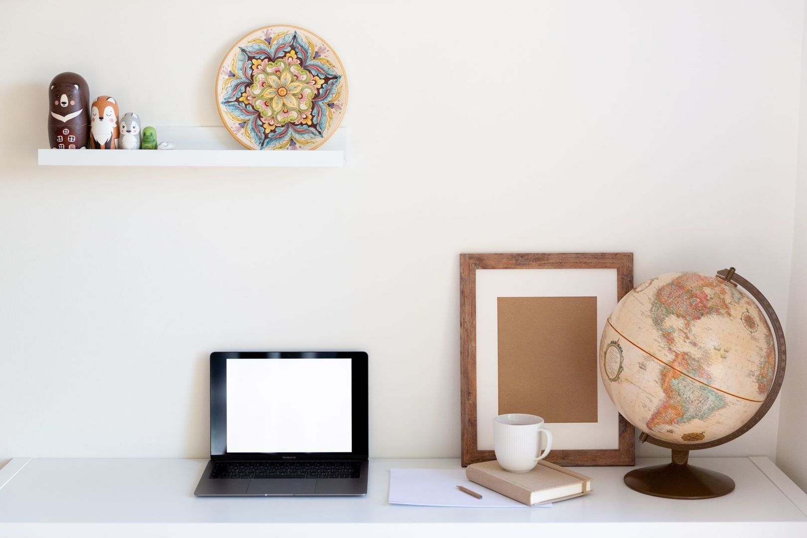 Rustig gestylede wandplank boven een werkplek met decoratie